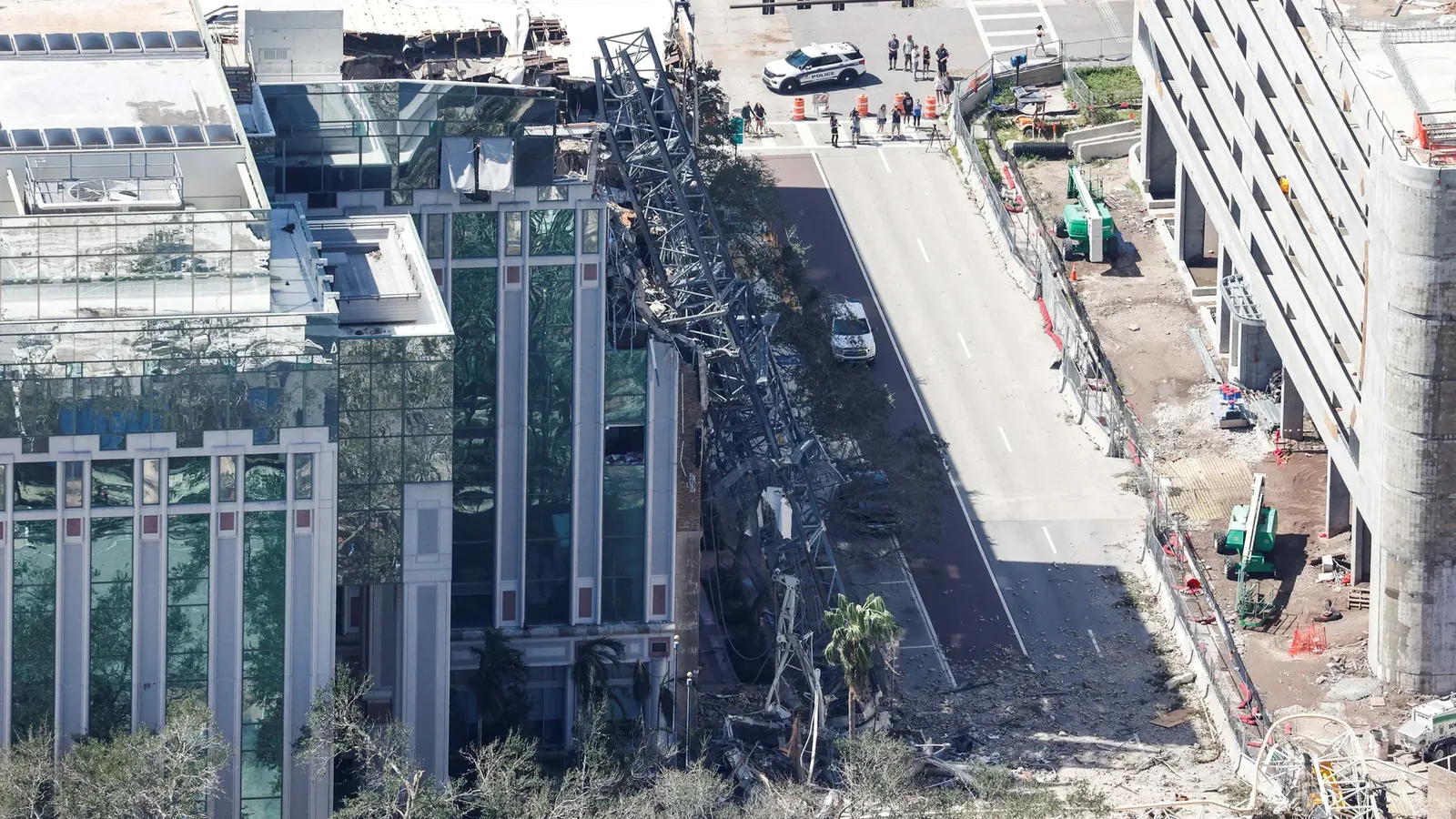 Aerial view of a construction crane collapsed across the street into a commercial building during Hurricane Milton
