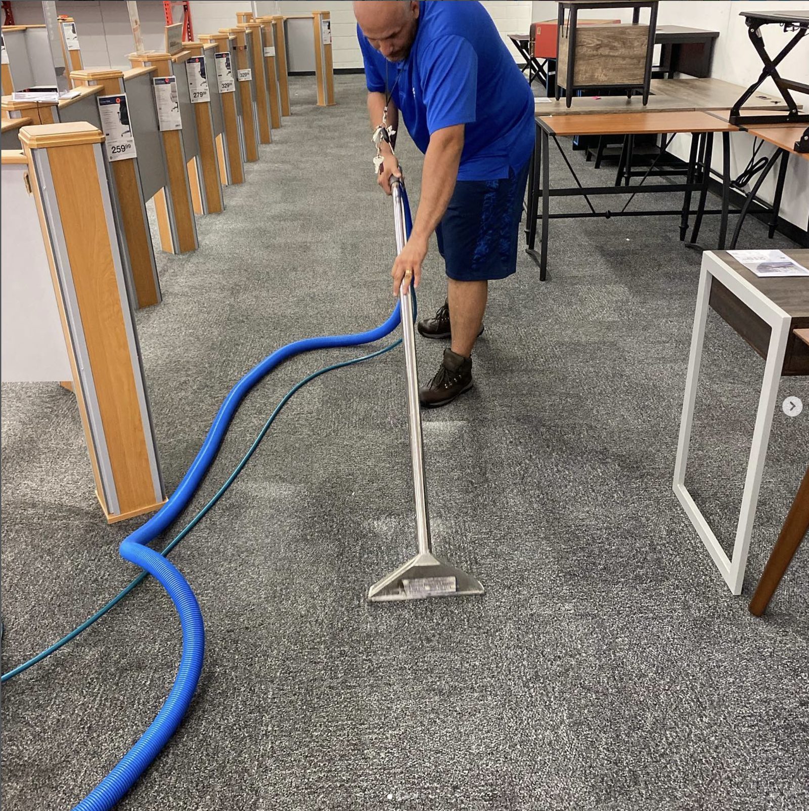 BlueSky technician hot-water extracting showroom carpet, leaving a visibly lighter clean pass