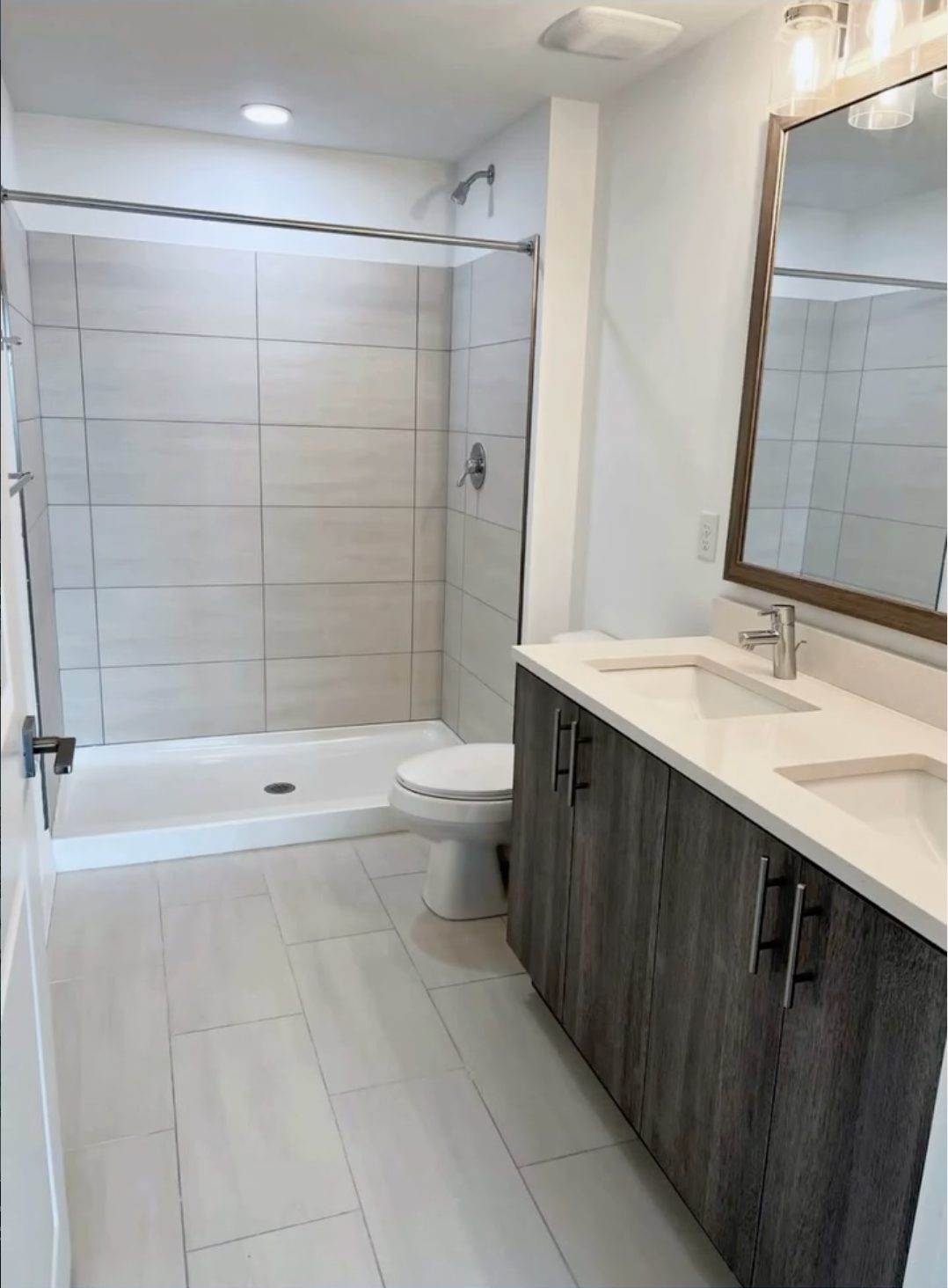 Same washroom turned over spotless with clean tile, shower pan and quartz vanity