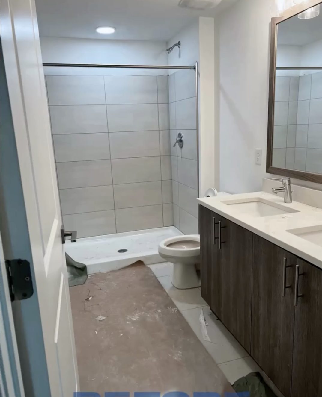 Washroom left with drywall dust, debris and drop cloths across the tile floor