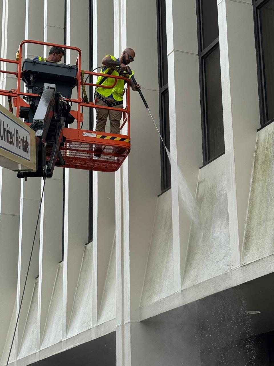 BlueSky technician performing pressure washing on a commercial facade