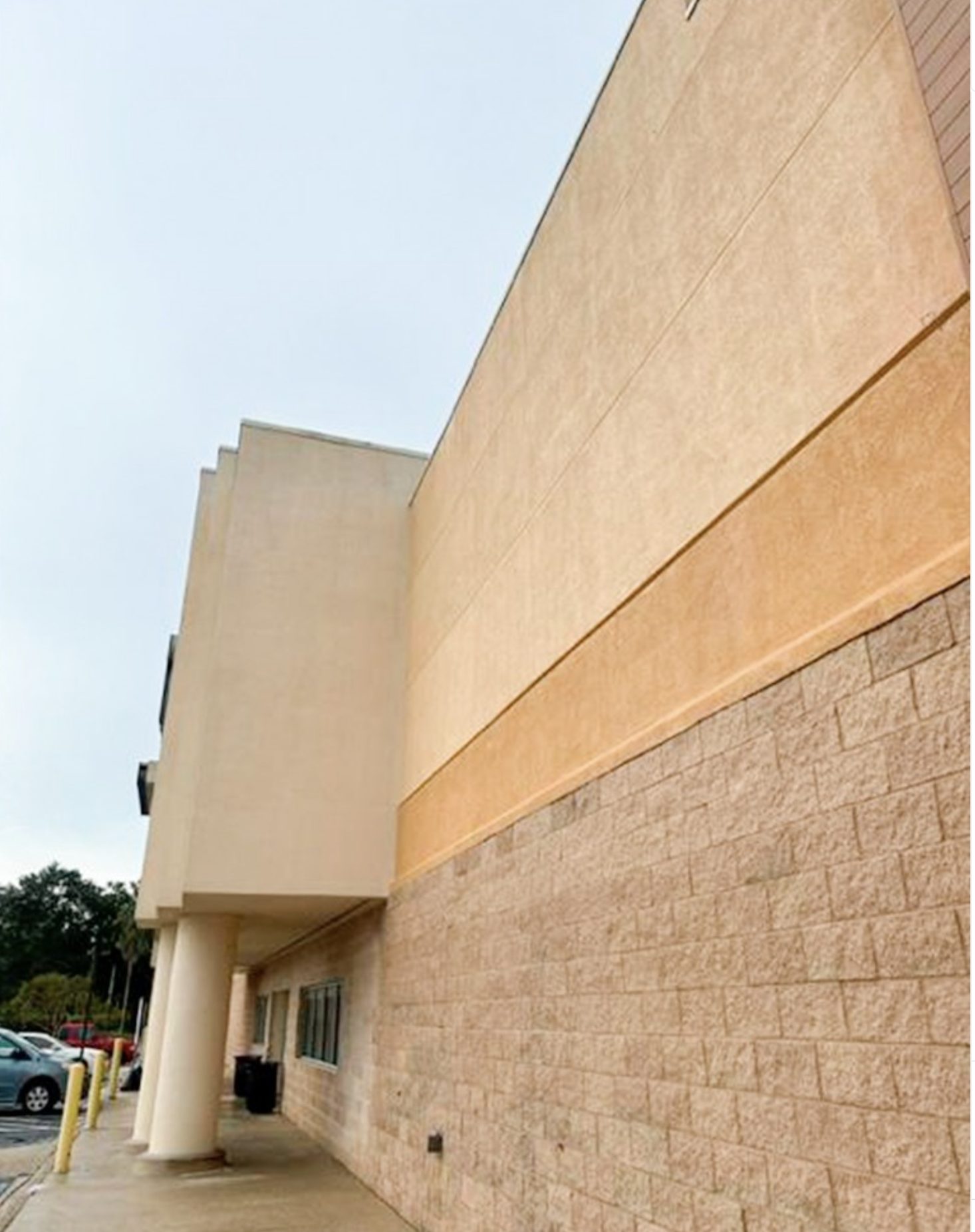 Same facade washed back to clean tan stucco and bright split-face block