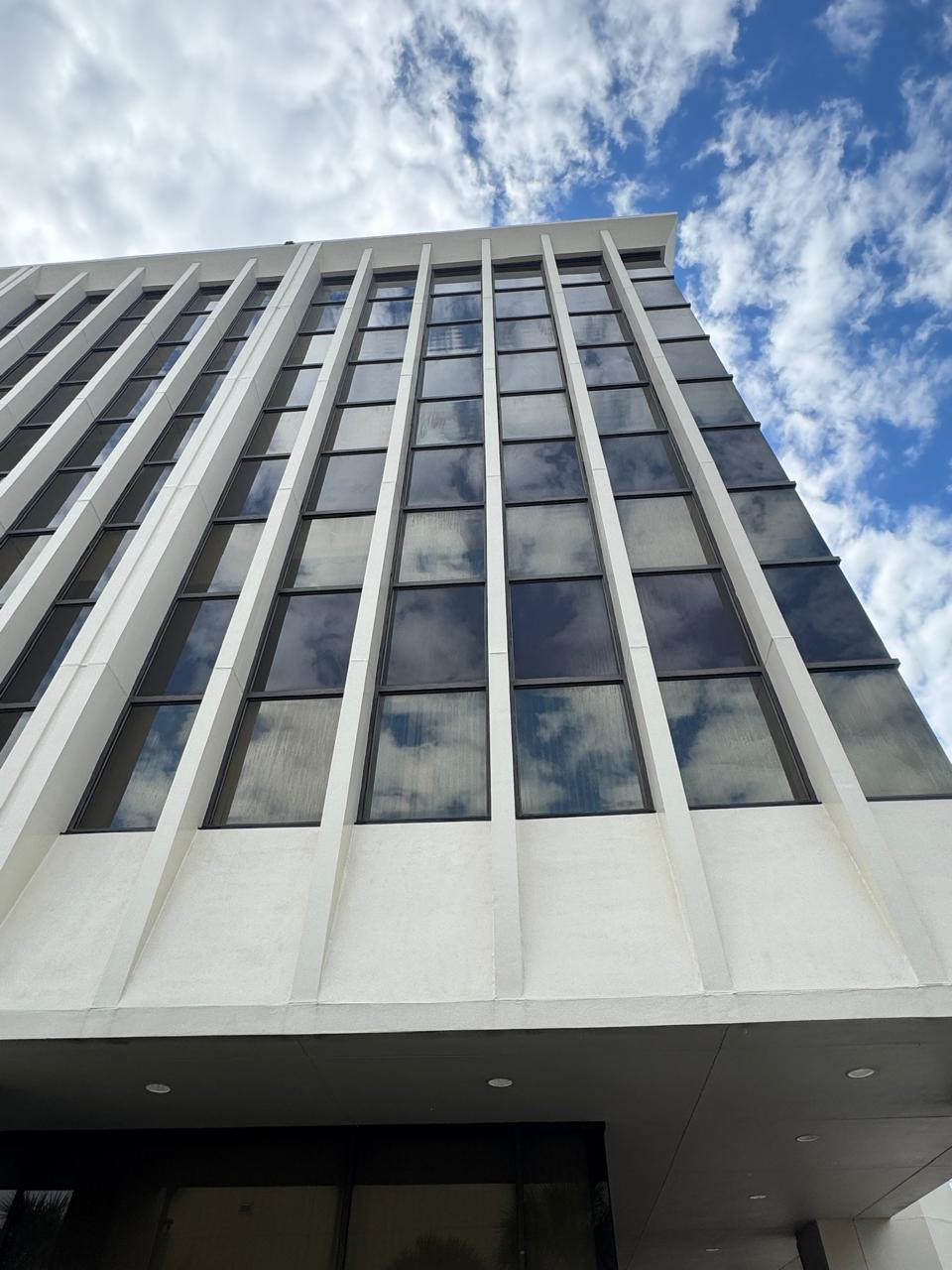 Same tower elevation cleaned to bright white precast with glass reflecting open sky